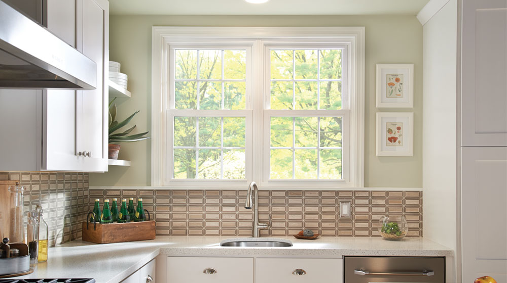 Modern blue house with large windows at dusk.