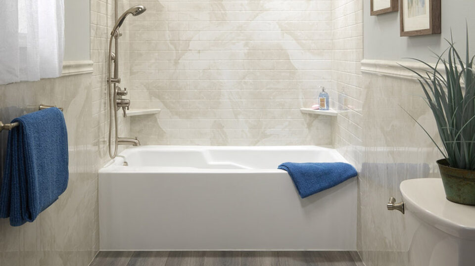 Modern bathroom with bathtub and blue towels.