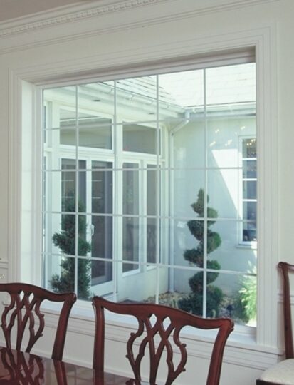 Large window view of garden with topiary trees.