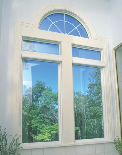 Large window with forest view and arch design.