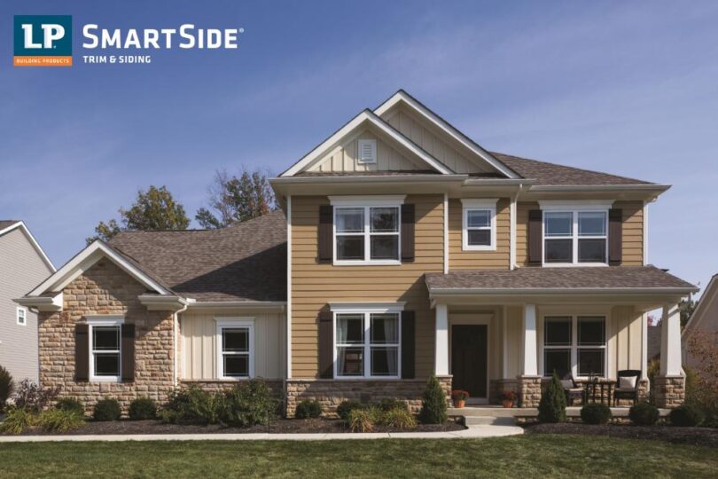 Two-story house with beige siding and stone accents.